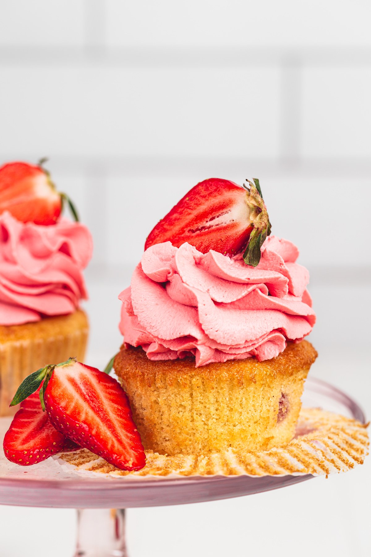 strawberry cupcakes topped with mascarpone frosting and fresh strawberries