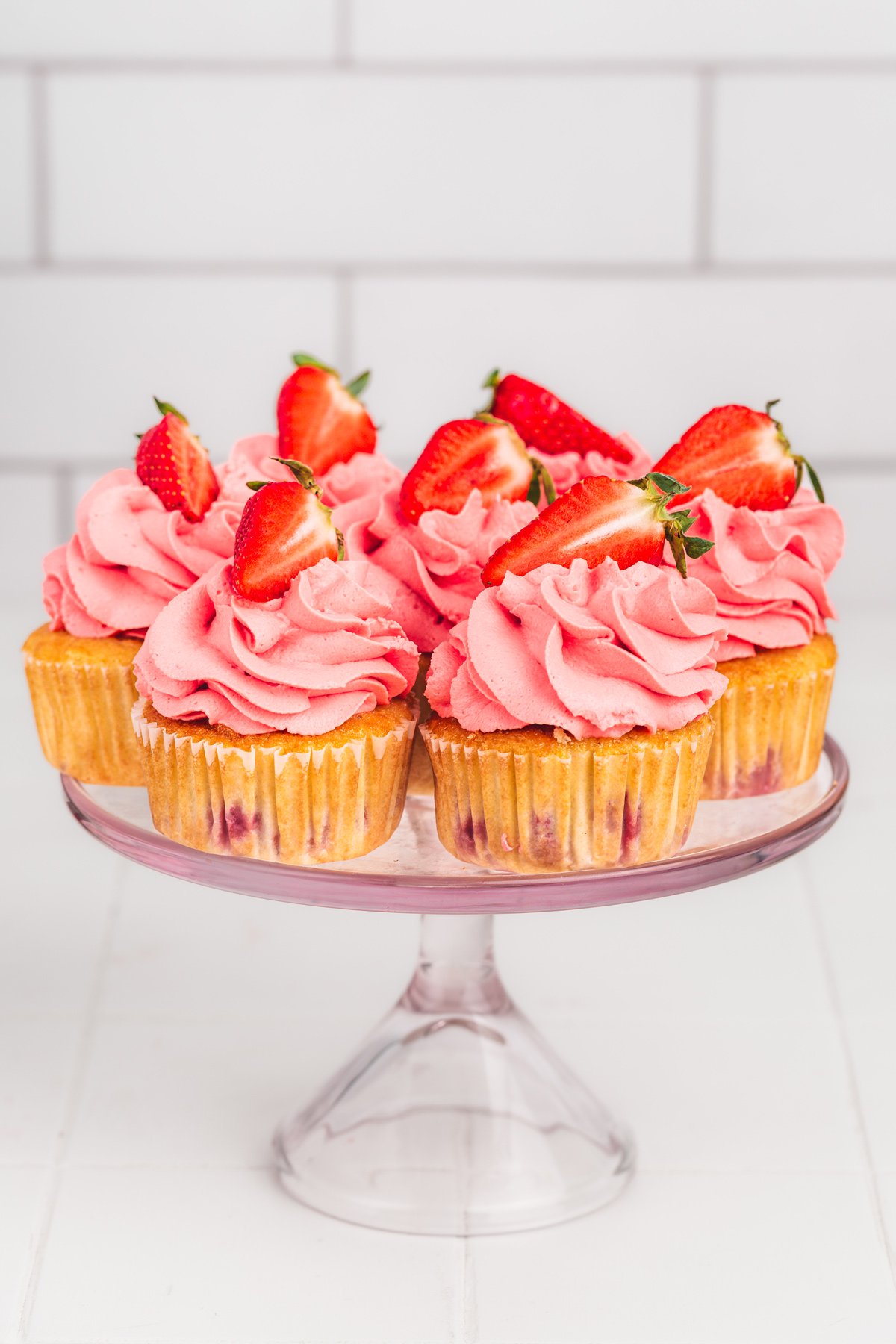 strawberry cupcakes with strawberry mascarpone frosting on a cake stand