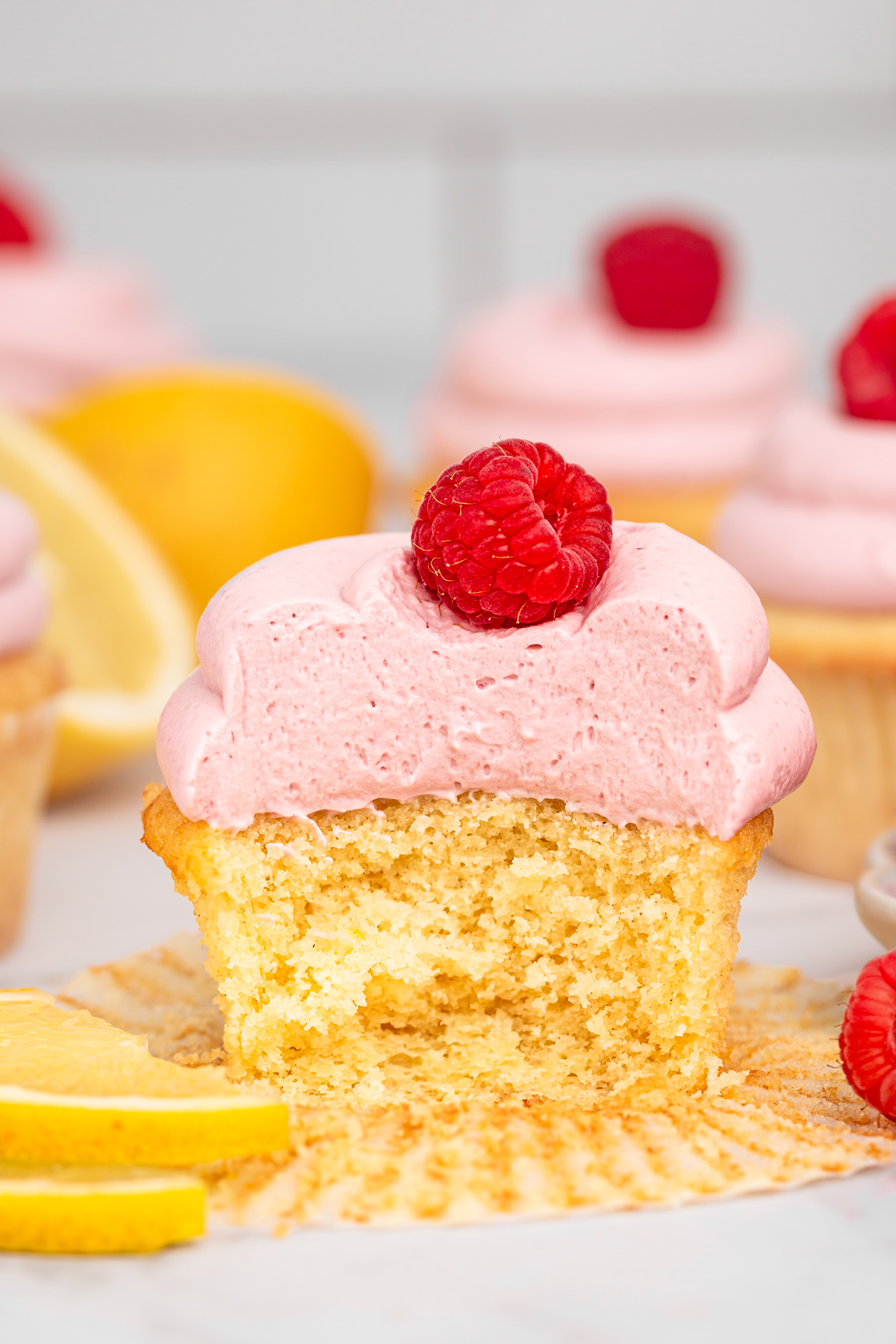 Lemon raspberry cupcake cut in half showing the inside filling