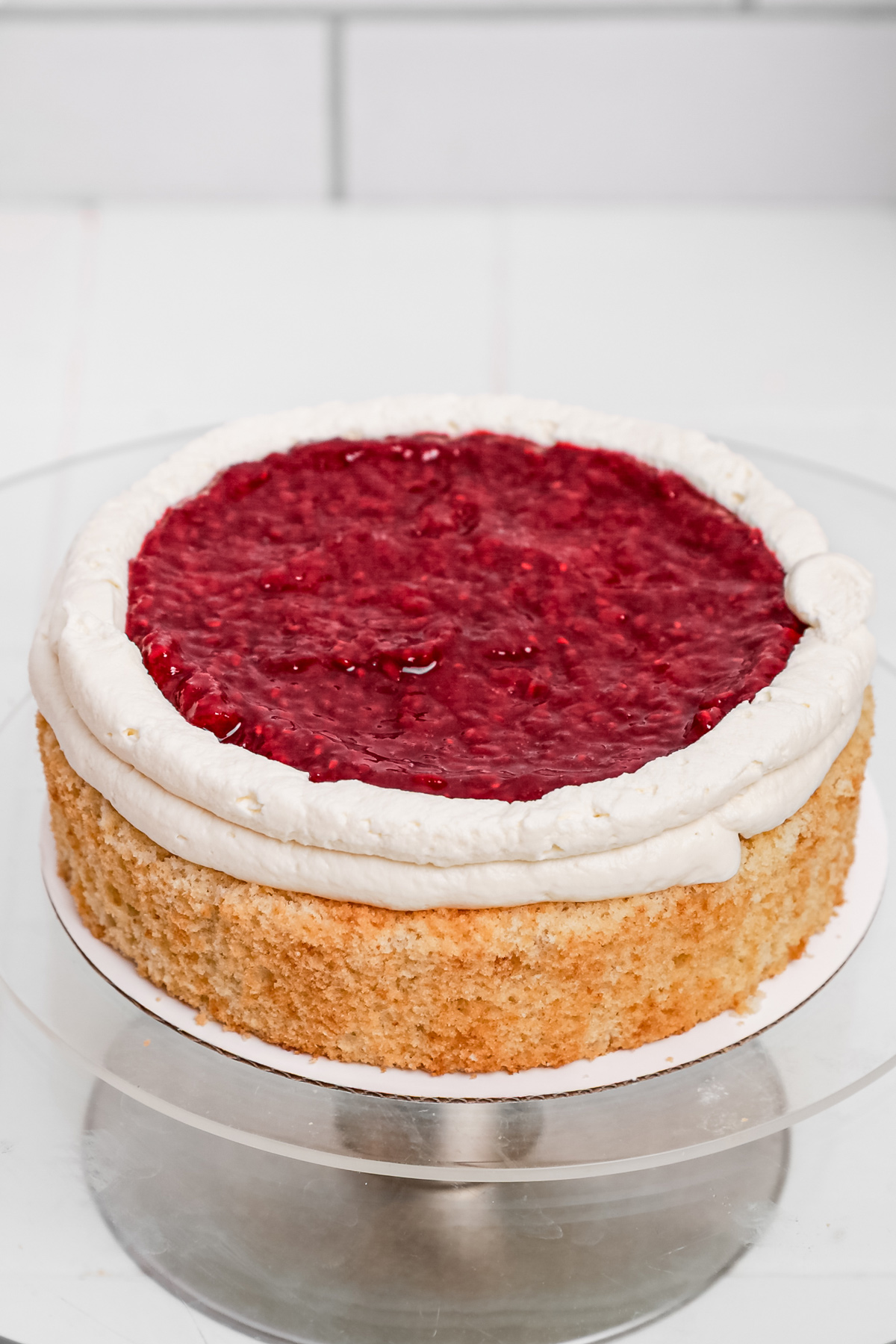 Vanilla cake layer filled with mascarpone frosting and raspberry compote