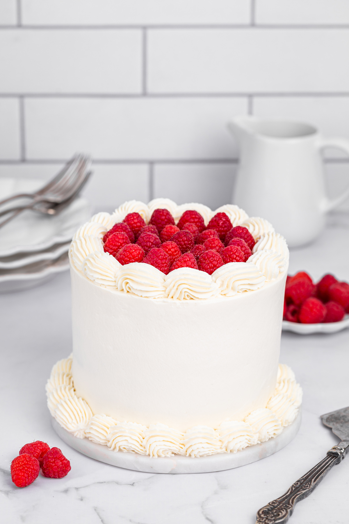 Raspberry mascarpone cake decorated with fresh raspberries on top