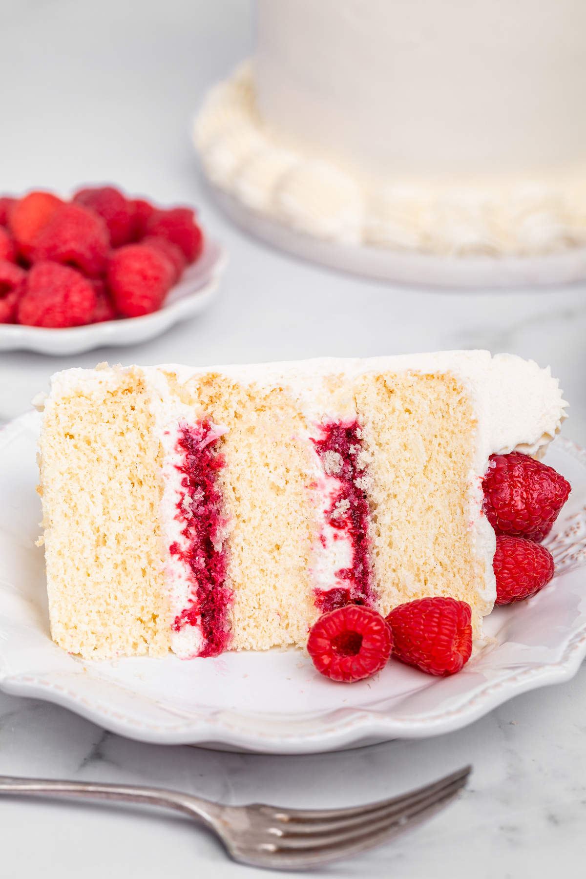 Slice of raspberry mascarpone cake on a dessert plate