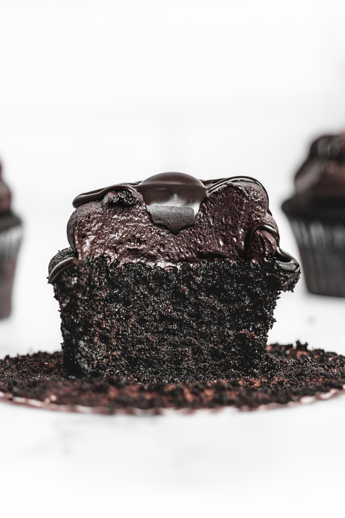black cocoa cupcake cut in half showing the soft chocolate crumb