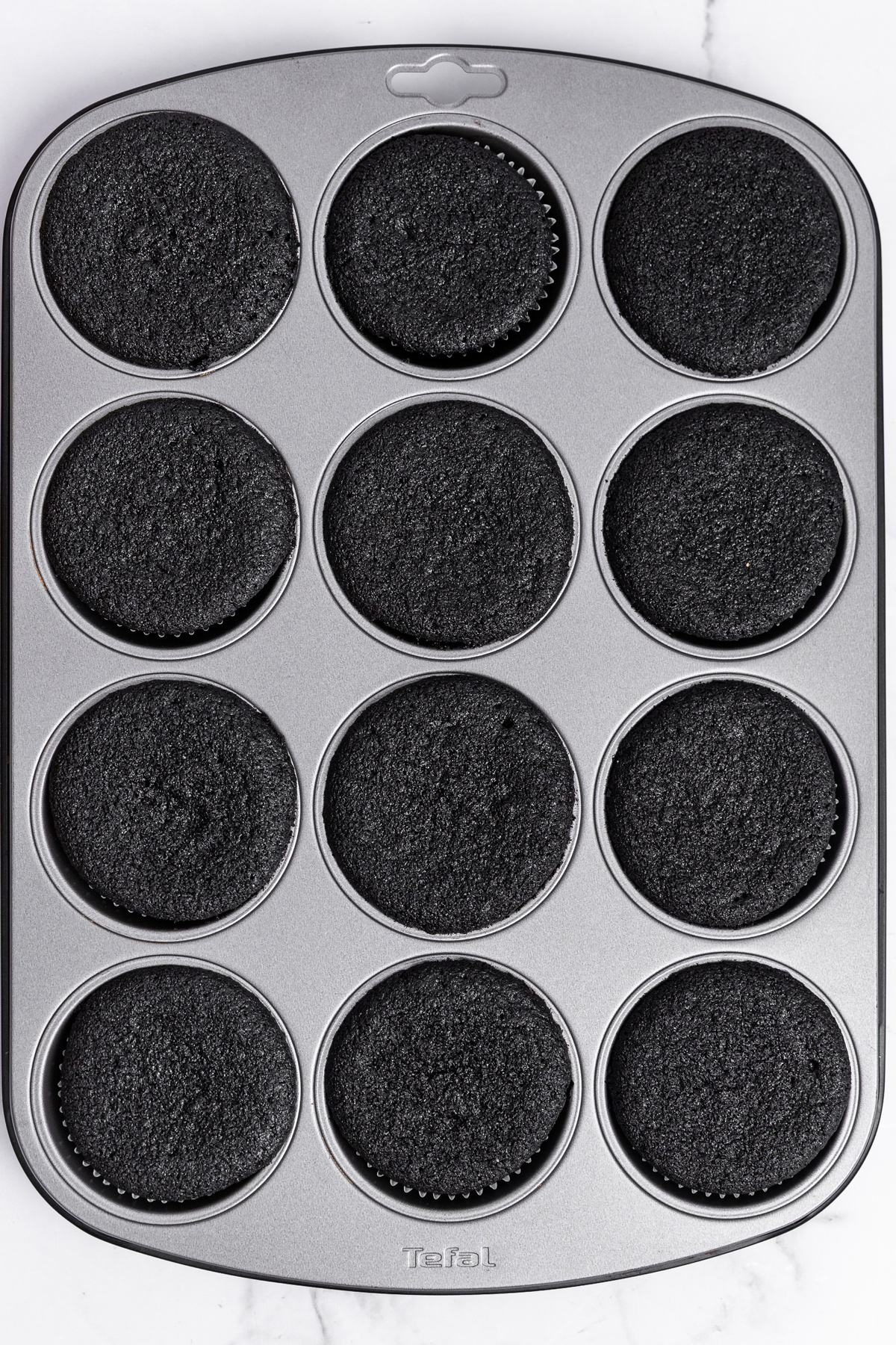 baked black cocoa cupcakes in a muffin pan