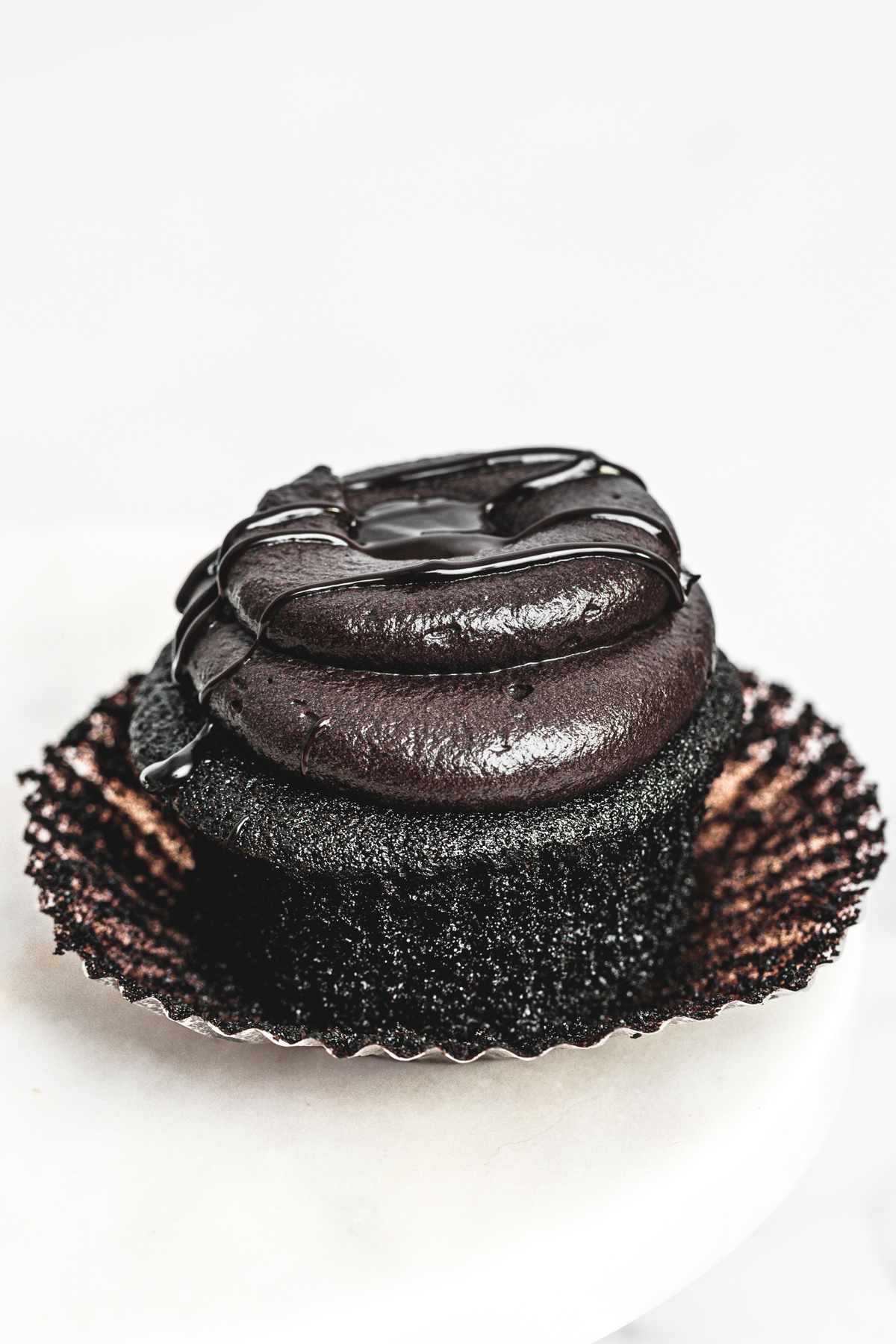 black cocoa cupcakes topped with black cocoa frosting and chocolate drip