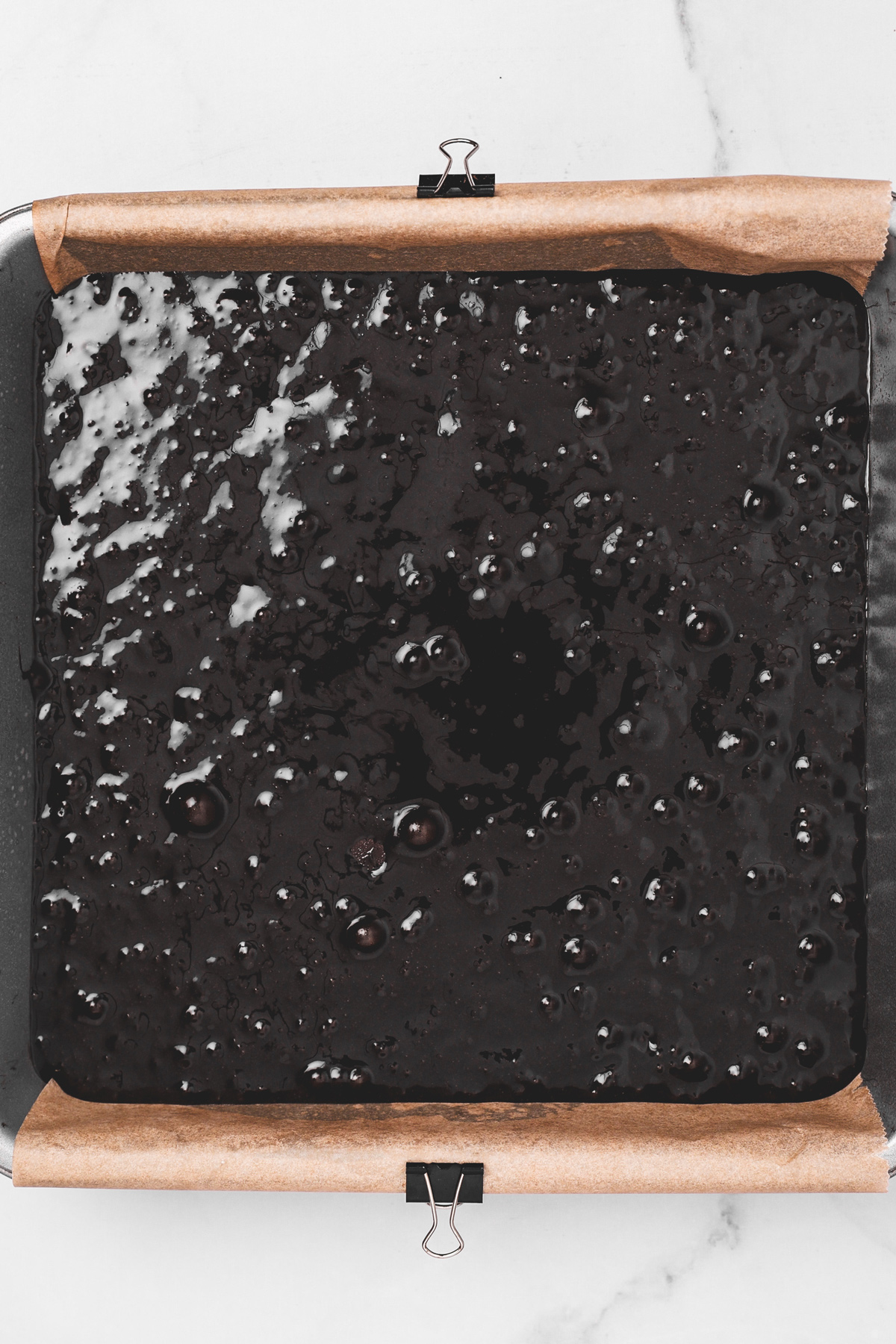 Black cocoa brownie batter in square baking pan