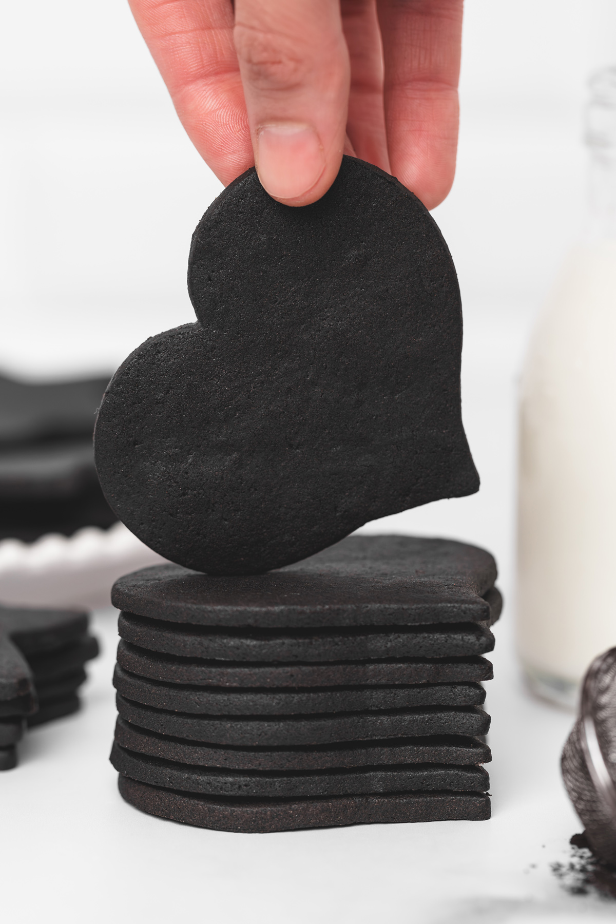 Black cocoa cut out sugar cookie heart held by hand