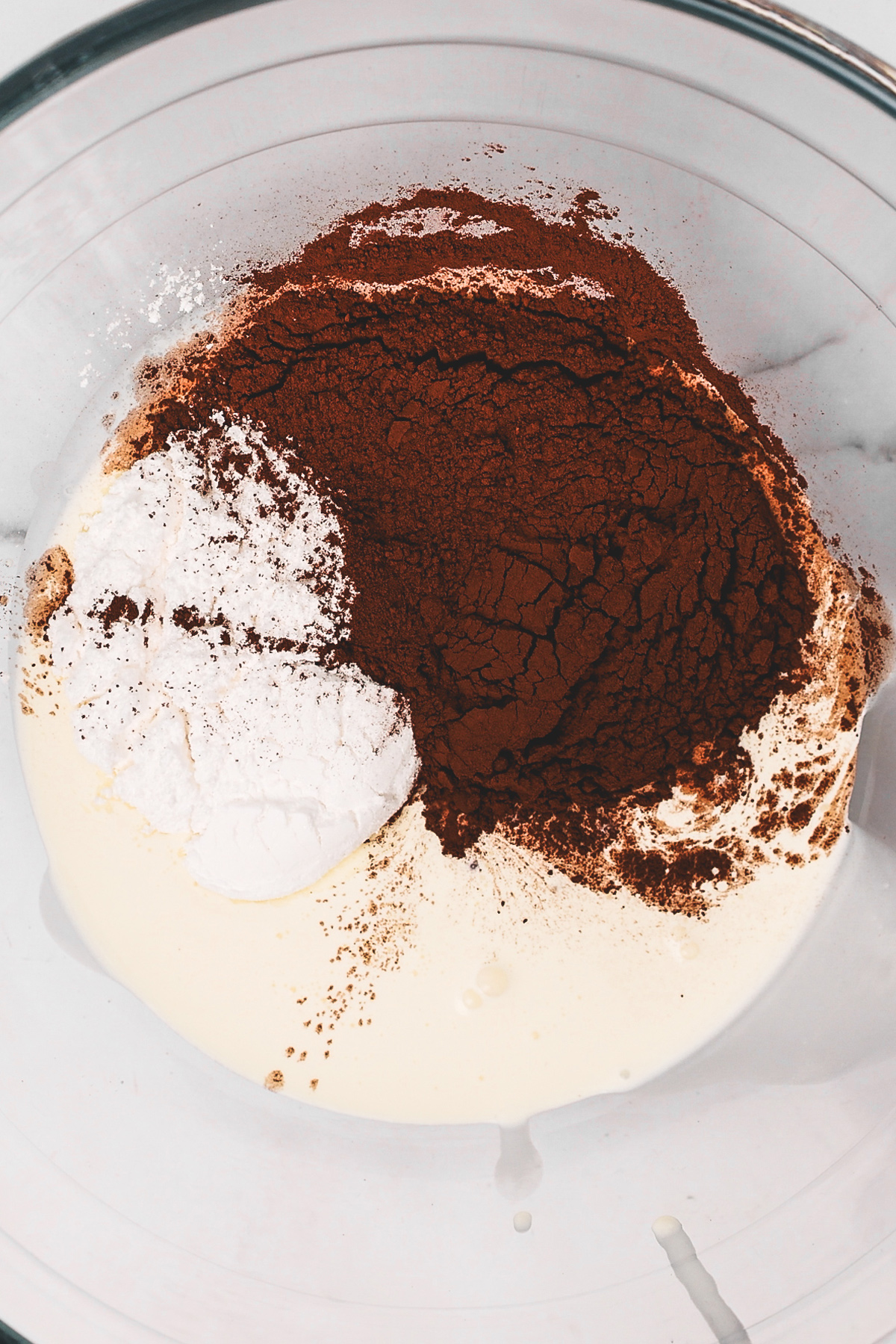 Chocolate whipped cream ingredients combined in a mixing bowl