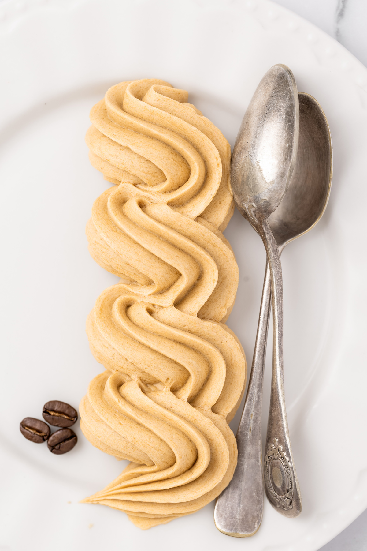 Coffee buttercream frosting piped on a plate