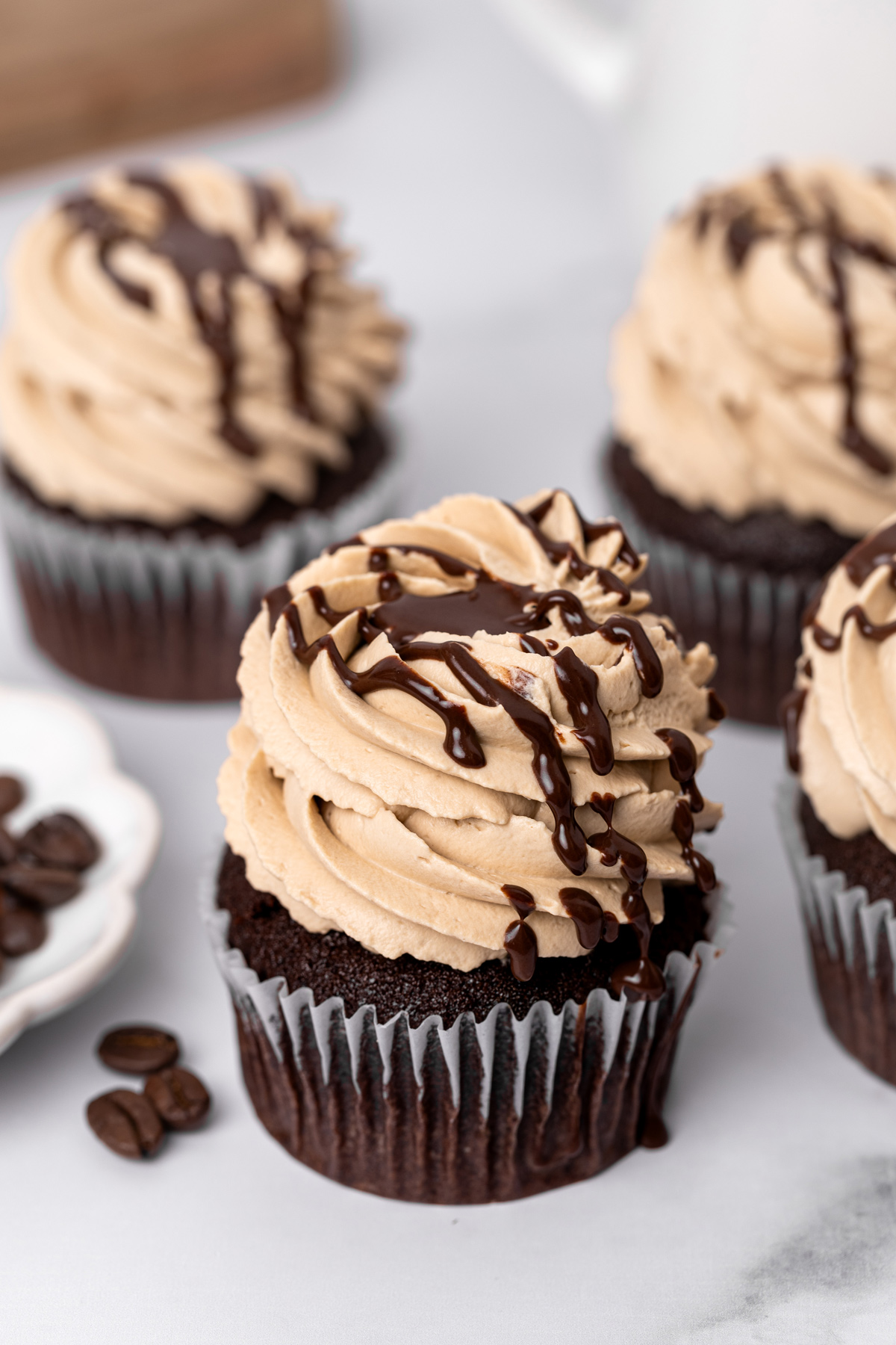 Mocha cupcakes topped with whipped coffee ganache on a table